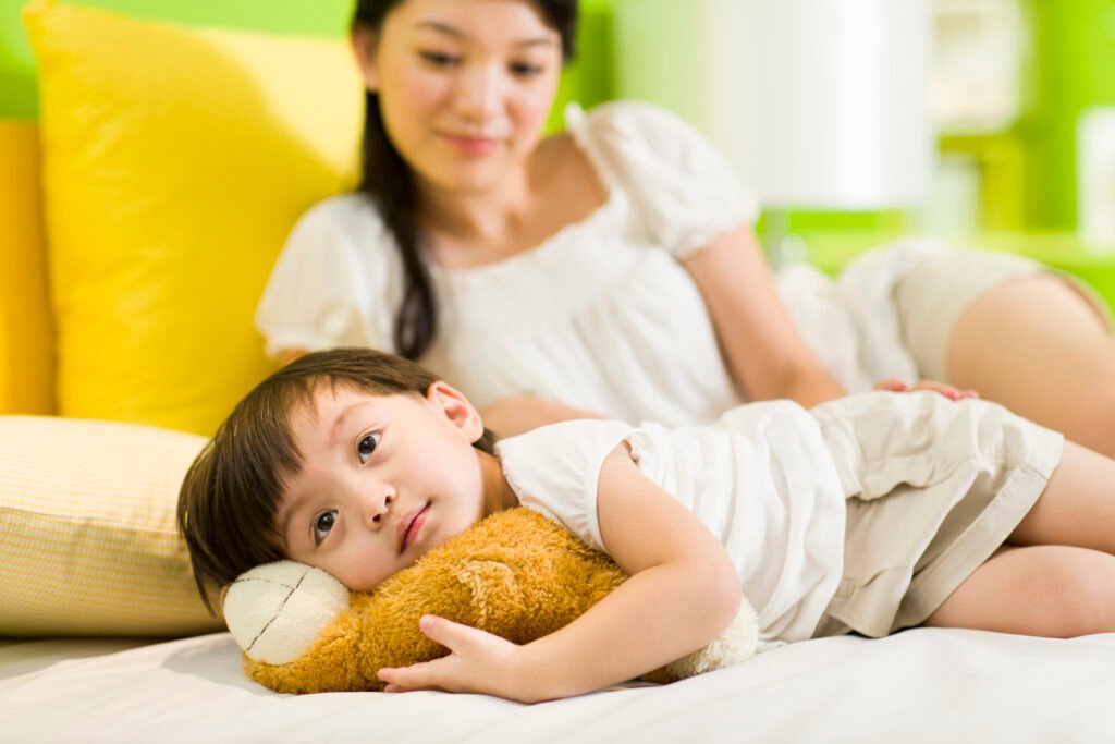 Chinese mother and daughter relaxing in bedroom